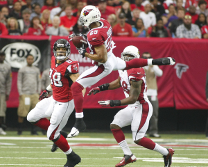 Cardinals safety Rhodes intercepts the ball as teammate linebacker Washington and Falcons tight end Gonzalez look on in the first half of their NFL football game in Atlanta.